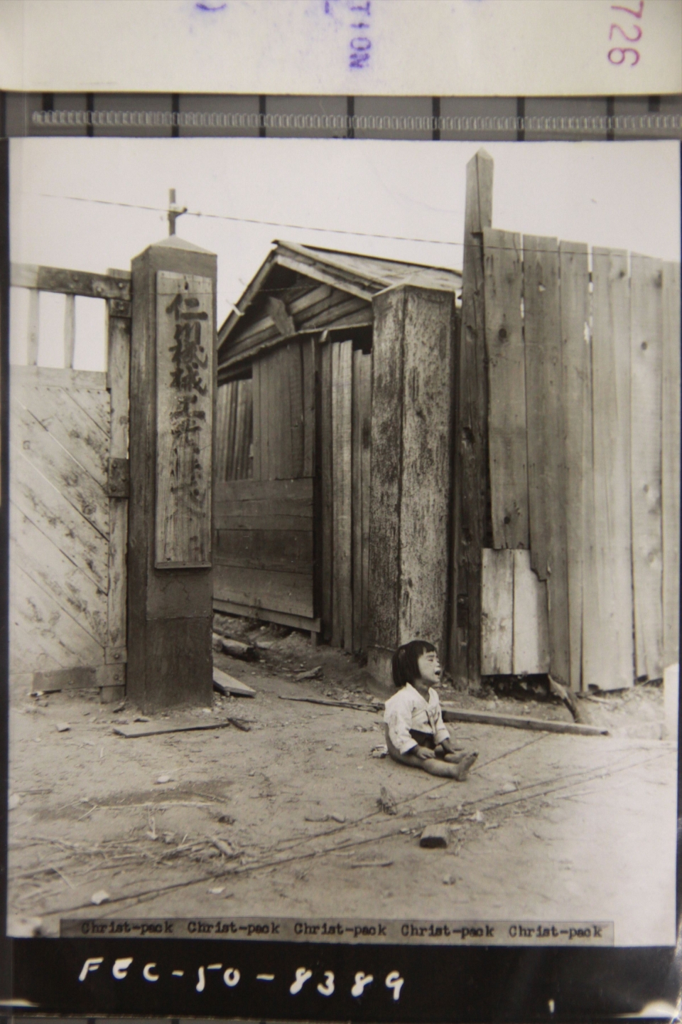 1950년 9월16일 인천상륙작전 이후 한 아이가 거리에 홀로 앉아 있는 모습. 아이 옆으로 '인천'으로 시작하는 간판이 걸려 있다. /사진제공=국사편찬위원회